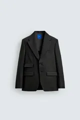 Blazer de corte regular confeccionado en lino, con solapas de muesca, cierre frontal de botones y múltiples bolsillos con solapa en la parte frontal. Presenta un diseño estructurado con abertura en la espalda y forro parcial.