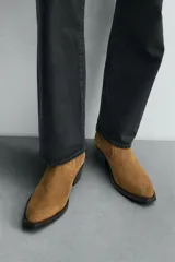 Bota de piel color marrón claro, estilo cowboy, con caña corta, puntera en punta y tacón cubano.