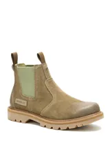 Bota Chelsea Caterpillar modelo Grader, confeccionada en gamuza color beige, con paneles laterales elásticos en tono verde claro, presillas traseras y suela de goma tractorada.