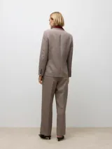 Blazer de corte regular con cuello sastrero y cierre frontal de botones. Presenta puños abotonados y está confeccionado en tejido plano con estampado de cuadros en tonos beige, negro y bordó.