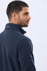 Buzo polar de abrigo en color verde oscuro, con cuello alto y medio cierre frontal. Presenta un bolsillo vertical en el pecho y bolsillos laterales, ideal para climas fríos.