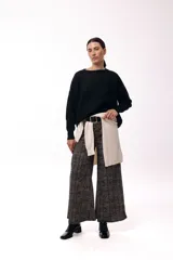 Sweater de punto de silueta relajada, con cuello redondo y hombros caídos. Presenta un diseño minimalista de manga larga con puños ajustados.