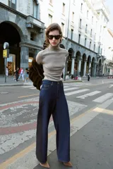 Jeans de tiro alto con pernera ancha y diseño combinado en dos tonos de denim. El panel central es de un lavado azul medio, mientras que los paneles laterales son de un lavado azul oscuro. Presenta cinco bolsillos y cierre frontal con cremallera y botón.