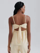 Blusa color beige de lino con breteles finos ajustables y detalle de botones decorativos.