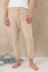 Pantalón de ramio y algodón color beige, con cintura elástica ajustable con cordón y ruedo con dobladillo.