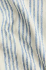 Pantalón de punto suave de corte relajado, con cintura elástica y piernas amplias con diseño a rayas en tonos claros y azules.