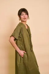 Vestido tipo túnica largo de lino color beige, de manga corta, con detalles de volados en el frente y bolsillos laterales.