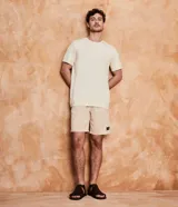 Bermuda masculina color gris claro, de sarga con efecto jaspeado, cintura elástica ajustable con cordón, bolsillos laterales y traseros, y etiqueta en la barra.