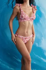 Conjunto de bikini de dos piezas con estampado floral en tonos rosa y marrón. El corpiño es de corte triangular con tirantes que se atan en los hombros. La bombacha es de corte clásico con tiras laterales ajustables.