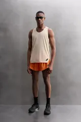 Musculosa deportiva color naranja con cuello redondo, sisas amplias y detalle de logo en el frente.