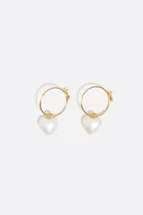 Aros tipo argolla dorados con dije colgante en forma de corazón perlado.
