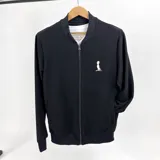 Campera bomber negra de algodón tipo waffle con cierre frontal y logo mediano bordado en color natural en el pecho. Tiene cuello, puños y cintura acanalados.