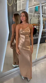 Vestido largo ajustado color oro rosado, con escote asimétrico de un solo hombro.