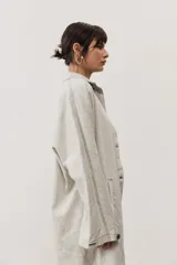Chaqueta gris de lino de corte oversize, con mangas largas y costuras en contraste.