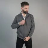 Campera tejida gris con cierre frontal, cuello alto y puños y cintura acanalados.