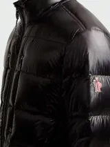 Campera corta acolchada de Moncler, modelo Orres, en color negro con acabado brillante. Presenta cuello alto, cierre frontal completo y dos bolsillos verticales con cierre en el pecho. Cuenta con puños elásticos y diseño técnico de la línea Grenoble.