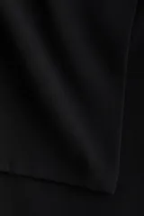 Pantalón acampanado de tiro alto con pollera mini superpuesta integrada, cierre frontal y botón.