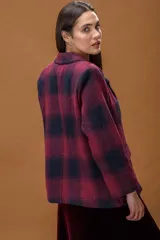 Blazer de tejido con textura y diseño de cuadros en tonos bordó y azul marino. Presenta solapa clásica, cierre frontal con un botón y bolsillos laterales con solapa.