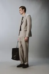 Blazer slim fit de color beige, confeccionada en tejido con lana. Presenta cuello con solapas de muesca, cierre frontal de un botón, bolsillos laterales con solapa y bolsillo de vivo en el pecho.