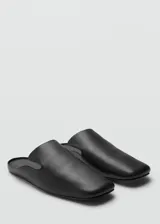 Zapatos tipo mule de piel ovino, color negro, diseño slip-on sin cierre, punta cuadrada y suela plana.