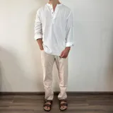 Camisa blanca de manga larga con cuello mao y abertura frontal con botones de madera. Tejido ligero con textura de lino.