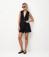 Bermuda midi de jean color negro, con cintura media, cierre de gancho, bolsillos laterales y detalle de costura frontal vertical.