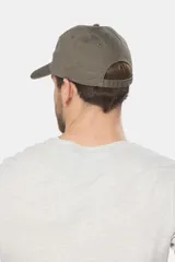 Gorro con visera de lona color verde oliva con parche circular de goma negro en el frente.