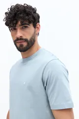 Remera básica de hombre con cuello redondo y mangas cortas, confeccionada en algodón. Presenta un pequeño logo bordado en el pecho.