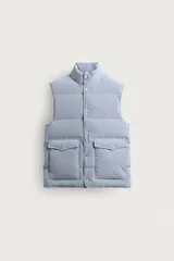 Chaleco acolchado de corte regular fit en color celeste, confeccionado en tejido técnico con relleno de plumón. Cuenta con cuello subido, bolsillos frontales de plastrón con solapa, bolsillo interior y cierre frontal con botones a presión.
