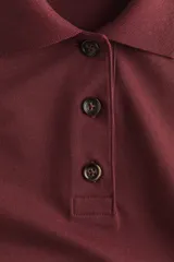 Remera polo de corte holgado confeccionada en piqué de algodón, con mangas al codo, hombros caídos y cuello acanalado. Presenta tapeta con botones y bajo recto con aberturas laterales.