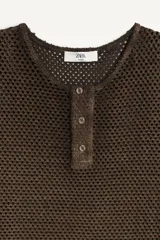 Camiseta de punto con estructura abierta tipo crochet, de corte relajado, cuello panadero con cierre frontal de botones y manga larga.
