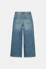 Jeans wide leg de tiro alto, color azul con efecto deslavado, cintura con trabillas, diseño de cinco bolsillos y cierre frontal con cremallera y botón metálico.