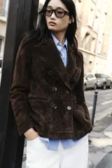 Blazer de ante color marrón, con cuello solapa, hombreras, manga larga y cierre frontal cruzado con botones. Cuenta con bolsillos delanteros de doble vivo.