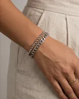 Set de dos pulseras de acero plateado, una compuesta por eslabones tipo cadena gruesa y otra por pequeñas esferas unidas.