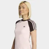 Remera Adidas de ajuste ceñido, color rosa claro con mangas y cuello en color marrón oscuro. Presenta las icónicas tres rayas de la marca en las mangas y el logo del trébol bordado en el pecho.