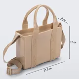 Cartera tipo tote bag Melissa modelo Mini Dulce, color beige con acabado brillante. Está fabricada en Melflex, un material de PVC flexible, e incluye asas de mano fijas y una correa ajustable y extraíble de tela con el nombre de la marca grabado.