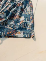 Short de baño Von Braun con estampado floral en tonos azules, naranjas y blancos. Cuenta con cintura elástica, dos bolsillos laterales y un bolsillo trasero con solapa y etiqueta de la marca.