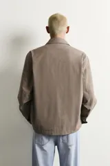 Sobrecamisa de corte regular fit confeccionada en tejido con mezcla de lana, con interior ligeramente acolchado. Presenta cuello solapa, cierre frontal con botones, mangas largas con puños abotonados y bolsillos laterales de vivo.