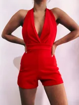 Mono corto de color rojo, con escote halter y espalda descubierta.
