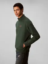 Buzo Calvin Klein de felpa color verde oscuro, con cuello alto, cierre frontal parcial de un cuarto y manga larga. Presenta el logo de la marca bordado en el pecho.