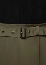 Vestido midi de diseño evasé con cuerpo de lyocell negro de manga larga y cuello barco, combinado con una falda de poliéster en color verde oliva que incluye un cinturón decorativo integrado.