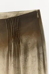 Pantalón de tiro medio con diseño estampado, confeccionado en viscosa. Presenta pliegues en la parte delantera y cierre lateral con cremallera oculta.