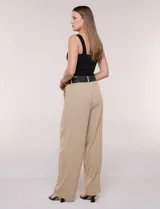Pantalón wide leg blanco con finas rayas verticales oscuras, tiro alto, bolsillos laterales y pinzas frontales. Incluye un cinturón trenzado de rafia con hebilla rectangular.