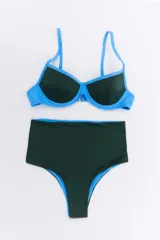 Bikini de dos piezas en combinación de colores negro y mostaza. El corpiño es de estilo triangular con base y breteles finos, mientras que la bombacha es de corte clásico con cintura alta en color negro.