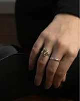 Anillo de plata 925 de banda chata con piedra central de citrino tallada en brillante de 8 mm, engarzada con detalles de esferas metálicas en los extremos.
