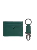 Set de regalo compuesto por un tarjetero y un llavero a juego, ambos confeccionados en piel Saffiano color verde. El tarjetero cuenta con múltiples ranuras para tarjetas y el escudo TH en relieve. El llavero incluye un cierre de pinza metálico y el logo de la marca grabado en la anilla.