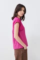 Remera fucsia de algodón con mangas cortas que presentan detalles de broderie y costuras decorativas.
