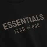 Camiseta negra de algodón con cuello redondo y corte oversize. Estampado con el logo "ESSENTIALS FEAR OF GOD" en el pecho.