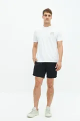 Short de baño liso con cintura elástica y cordón ajustable. Cuenta con dos bolsillos laterales, un bolsillo trasero y logo bordado en el ruedo. Confeccionado en tejido ligero de secado rápido.