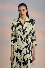 Blazer cruzado con estampado abstracto en tonos verde claro y negro, con solapas de muesca, corte entallado y botones dorados.